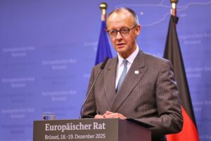 Friedrich Merz diskutiert über EU-Ukraine-Hilfen, umgeben von enttäuschten Politikern und Medienvertretern.