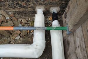 Zwei Arbeiter installieren Fernwärmeleitungen in Hamburg für klimaneutrale Wärmeversorgung bis 2040.