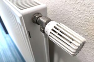 Eine moderne Heizung neben einem Wärme- oder Energiesymbol, um nachhaltige Wärmelösungen darzustellen.