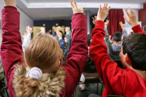 Kinder in einer Schule, Symbole für Bildung und Kinderrechte, die im Fokus stehen.