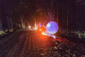 Milchlaster im Seitenraum, aufgewühltes Erdreich, Polizei und Räumfahrzeuge im Einsatz.