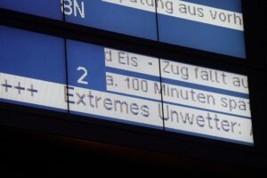 Anzeigetafel mit Warnhinweisen zu Verspätungen und Sanierungsarbeiten im Bahnverkehr.