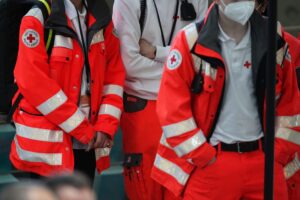 Ein Rettungssanitäter hilft bei einem Einsatz, symbolisiert den Schutz für Einsatzkräfte und Gesundheitspersonal.