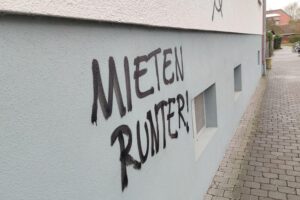 Graffiti mit "Mieten runter" symbolisiert Kampf gegen steigende Indexmieten und für Mieterschutz.