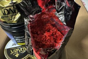 Sichergestellter Shisha-Tabak und Zollbeamte bei Kontrollaktion in Köln.