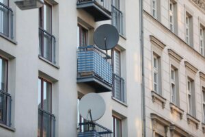 Satellitenschüssel an Wohnhaus symbolisiert moderne Wohnbedingungen in Erfurt, Bezug auf sozialen Wohnungsbau.