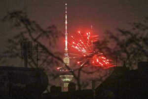 Silvesterfeuerwerk über dem Berliner Fernsehturm, symbolisiert die Kontroverse um Böllerverbot.