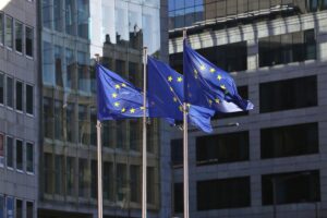 EU-Fahnen im Hintergrund, während Politiker über Entgelttransparenz und Bürokratie diskutieren.