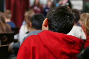 Kinder in einer Schule, die miteinander lernen und interagieren, symbolisieren steigende Bildungsausgaben 2024.