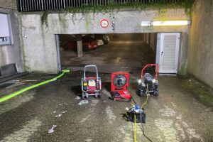 Feuerwehr beim Lüften einer Tiefgarage nach Brand mit starkem Rauch.