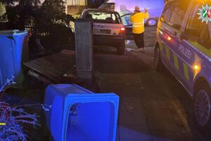 Ein beschädigter Pkw im Vorgarten nach einem nächtlichen Unfall auf einer Kreuzung.