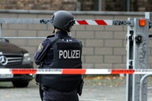 Polizistin hinter Absperrband, symbolisiert neue Polizeistruktur in Hambergen und Bürgernähe.