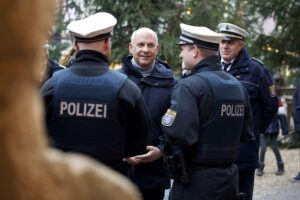 Innenminister Poseck und Polizeipräsident Tegethoff am Weihnachtsmarkt, Sicherheitsüberprüfung bei Publikum.