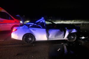 Zerschmetterter Mercedes nach schwerem Unfall auf Autobahn, Polizei und Rettungskräfte im Einsatz.