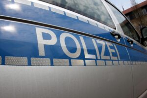 Polizeiauto an Unfallstelle auf Landesstraße, Rettungshubschrauber und Verkehrsabsperrungen sichtbar.