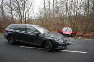 Zwei Unfallfahrzeuge, Feuerwehr, Polizei, Verletzte, Straßenrand, Unfallstelle, zerstörte Fahrzeuge.