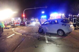 Zwei beschädigte Autos nach Kollision an einer Kreuzung, Polizei befasst sich mit Unfallursache.