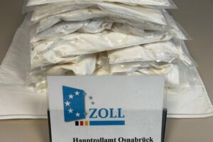 Zollbeamte überprüfen ein Auto an der Grenze und entdecken versteckte Drogenpakete.