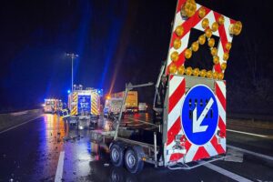 Unfall an Autobahn 57: Pkw kollidiert mit Baustellenanhänger, Feuerwehr und Rettungsdienst im Einsatz.