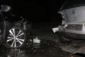 Vier beschädigte Autos auf einer Straße nach einem Verkehrsunfall. Polizei und Verletzte vor Ort.