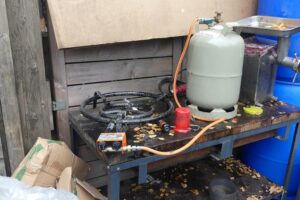 Illegale Shisha-Tabak-Anlage mit beschlagnahmten Zutaten und Maschinen in einer versteckten Halle.