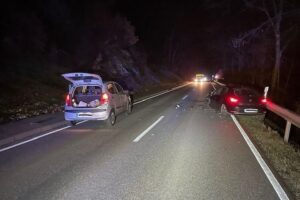 Zwei beschädigte Fahrzeuge nach Frontalzusammenstoß auf Landstraße, Polizei und Rettungsdienst vor Ort.