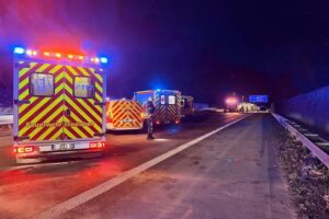 Rettungsfahrzeuge und Einsatzkräfte sichern Unfallstelle auf Autobahn mit verletzten Personen.
