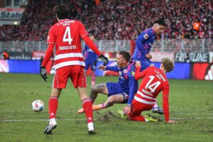 Zwei Fußballteams im Wettkampf, Spannung und Emotionen auf dem Spielfeld während eines Bundesligaspiels.