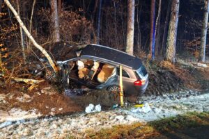 Verunfallter PKW, Feuerwehr bei Rettungsaktion, Straße abgesperrt, Einsatzkräfte im Einsatz.