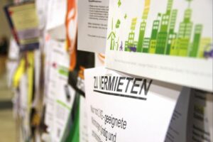 Wohnungsanzeigen und Dokumente, symbolisierend rechtliche Aspekte der Untervermietung in Deutschland.