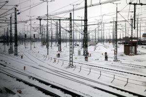 Zug fährt durch schneebedeckte Landschaft, winterliche Bedingungen, stark eingeschränkter Bahnverkehr in Norddeutschland.
