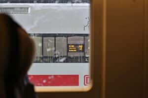 Verspäteter ICE im Winter, Schneechaos, Bahnfahrgäste warten geduldig auf Informationen.