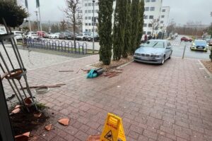 Unfallauto vor Hallenbad, beschädigte Fassade, Polizei im Einsatz, stark alkoholisierte Fahrerin.