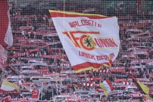 Fans von Union Berlin feiern, während Polizei Präsenz zeigt, um mögliche Ausschreitungen zu verhindern.