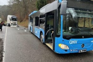 Linienbus und Lastwagen nach Unfall, sichtbare Schäden, Polizei im Einsatz, keine Verletzten.