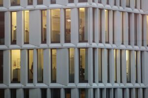 Moderne Büros mit Mitarbeitern, die in verschiedenen Arbeitsmodellen tätig sind, symbolisieren Diskussion um Teilzeit.