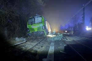 Feuerwehr sichert Betriebsstoffe nach Triebwagenentgleisung in Hattersheim am Main bei Nacht.