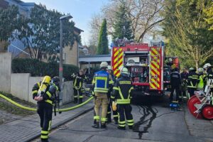 Einsatzkräfte der Feuerwehr löschen Küchenbrand, retten Bewohner aus verrauchtem Gebäude in Königswinter.