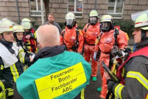 Einsatzkräfte der Feuerwehr besprechen Lage in Bonner Tiefgarage nach chemischem Reinigungsmittelvorfall.