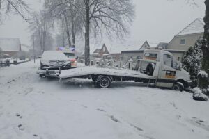 Unfall mit Autotransporter, Polizei im Einsatz, glatte Straßen, leicht verletzte Personen.
