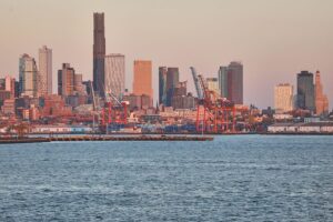 Industrieanlagen und Hafen in New York; Symbol für wirtschaftliche Herausforderungen und internationale Beziehungen.
