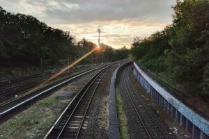Bahnstrecken mit Schienen, pendelnde Personen und ein Signal für Klimaschutz und Mobilität.