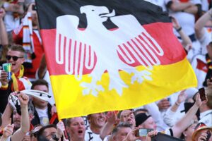 Deutsche Fußball-Fans in aufregender Stimmung, umgeben von Teamfarben und WM-Atmosphäre, genießen das Spiel.
