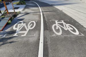 Radfahrer auf einem neu gebauten Radweg, umgeben von urbaner Natur in Hamburg.