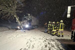 Unfallstelle mit Polizeiauto, schneebedeckte Straße, Einsatzkräfte und Warnschilder sichtbar.