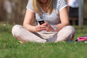 Smartphone-Nutzerin interagiert mit digitalem Gesundheitstool zur vereinfachten Patientensteuerung im Gesundheitswesen.