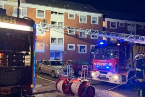Küchenbrand in Aurich: Feuerwehr im Einsatz, verletzter Bewohner, Rauch, Rettungsmaßnahmen.