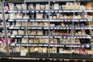 Käseregal im Supermarkt, symbolisiert steigende Lebensmittelpreise und Forderungen nach Entlastungen.