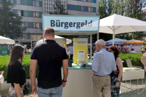Passanten informieren sich am Infostand über das geplante Bürgergeld und Sozialreformen.