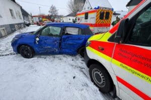 Rettungswagen und Pkw kollidieren, Feuerwehr sichert Unfallstelle, drei Personen leicht verletzt.